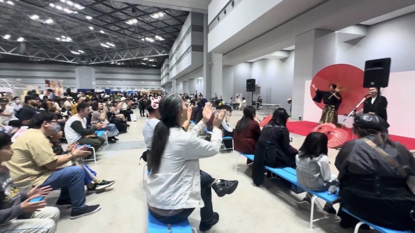 大きな赤い和傘を背景に、観客へ和の演技を届ける舞台